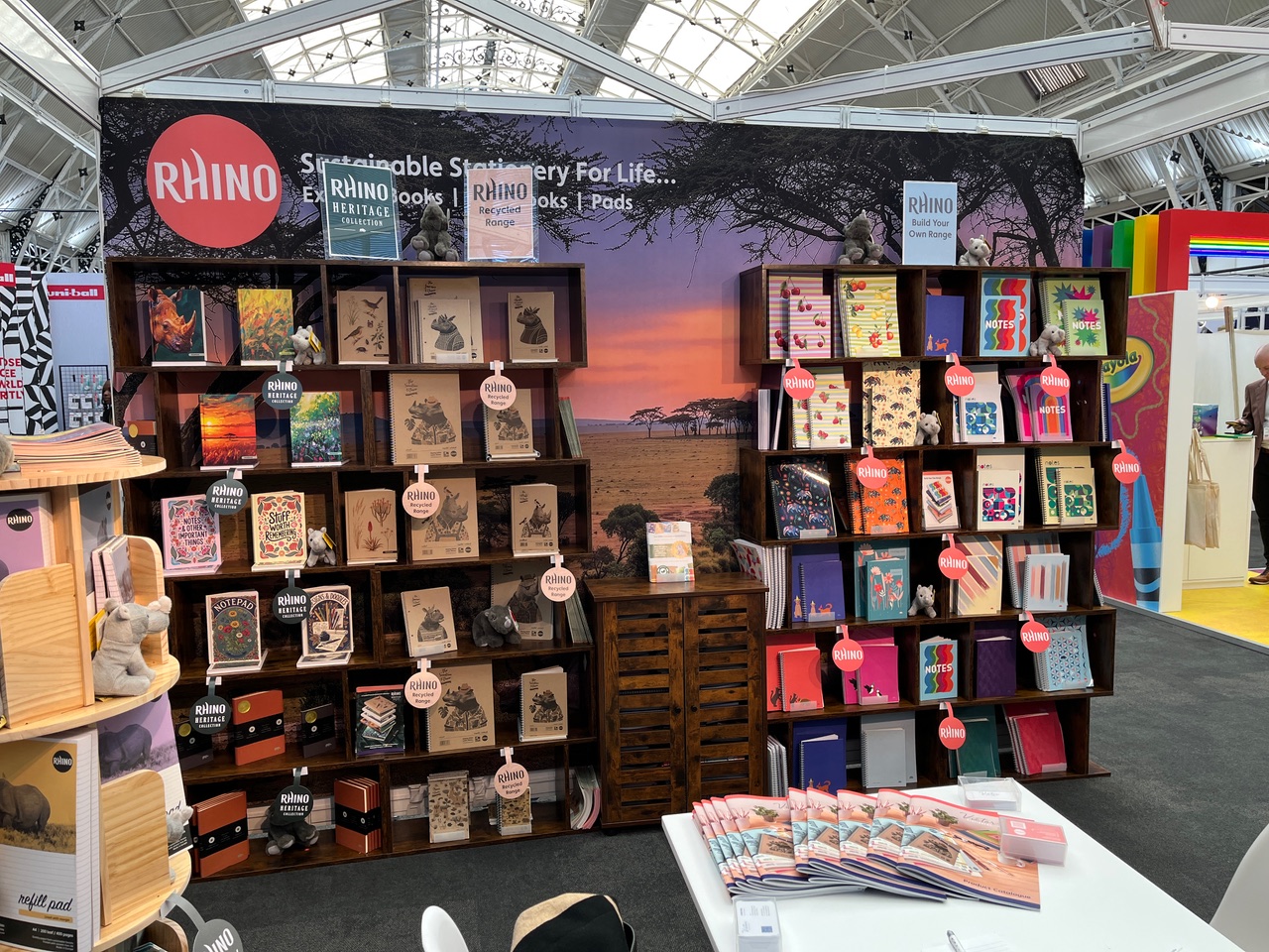 RHINO stationery displayed on shelving in front of a seamless African landscape exhibition backdrop